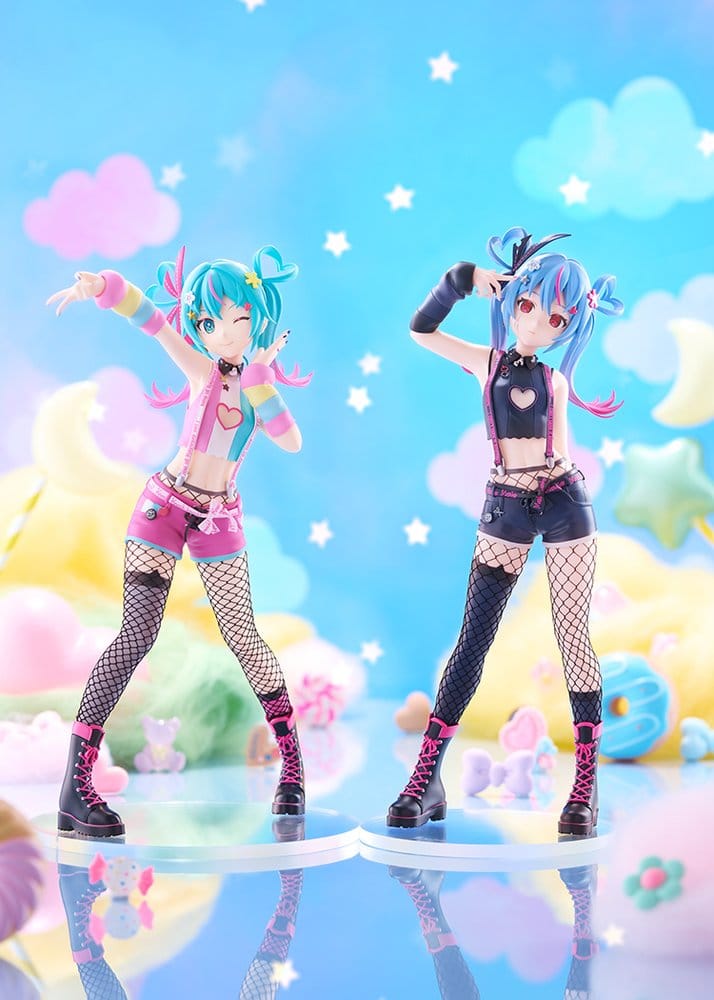 Two anime-style female figurines posed side by side on a glossy blue surface against a pastel sky backdrop with clouds, stars, and soft decorative objects. The left figure has turquoise hair, a pink-and-white outfit, fishnet stockings, and black boots.