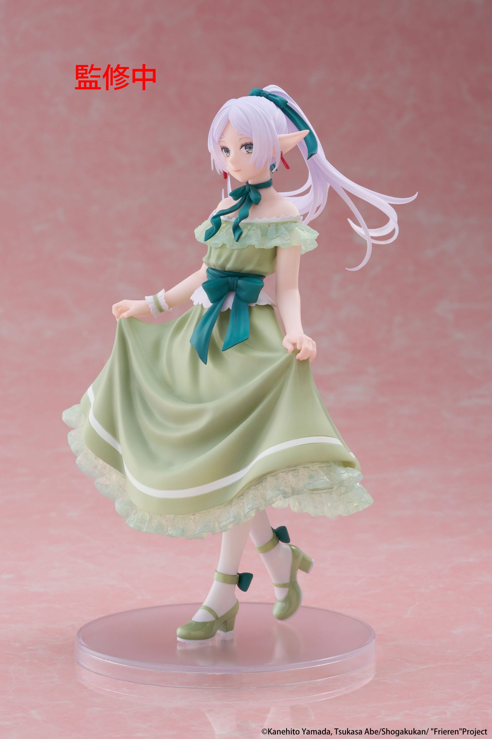 Figurine of a character in a green dress with blue accents on a pink background