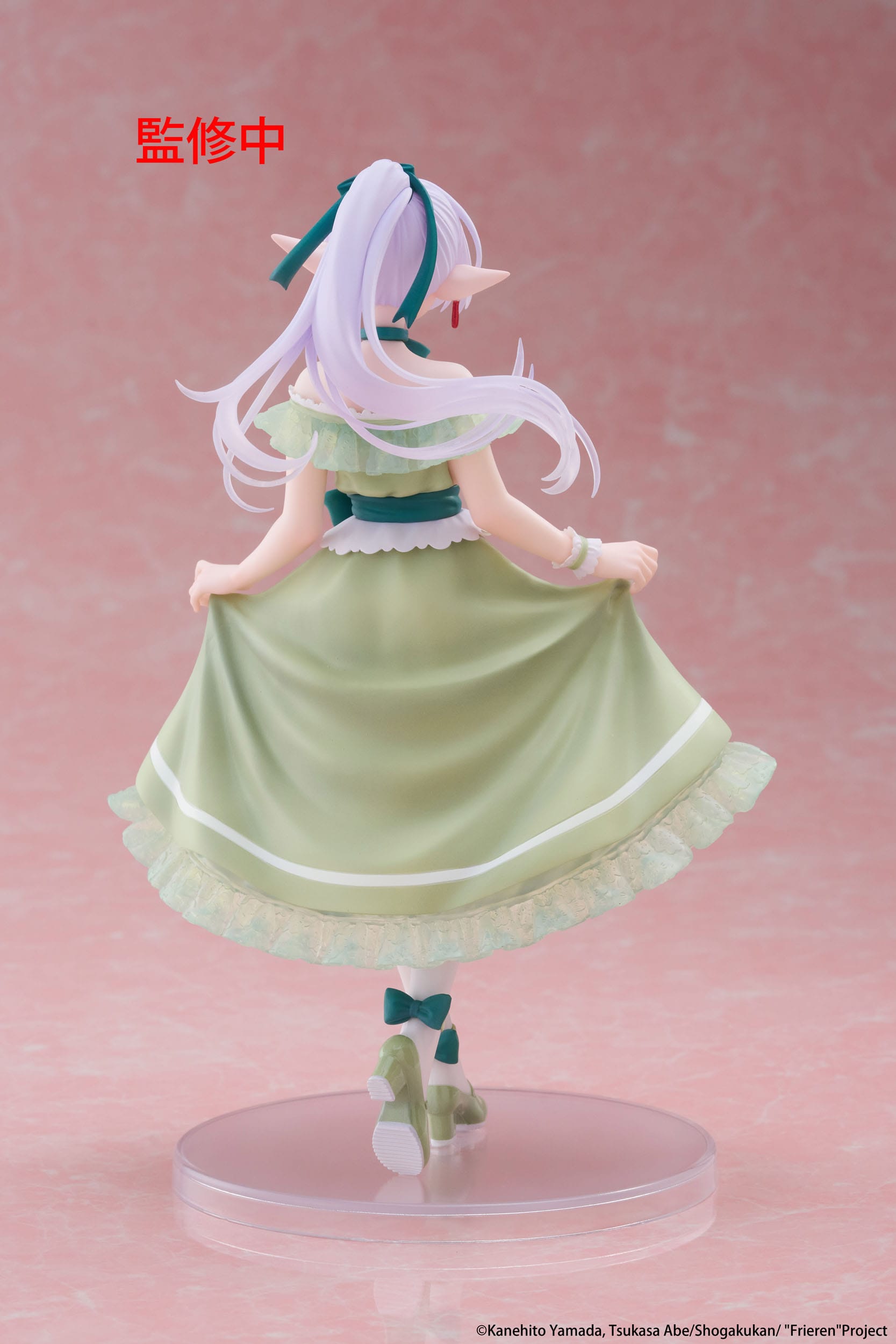 Figurine of a character in a green dress with white hair on a pink background