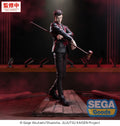 Action figure of a character from 'Jujutsu Kaisen' holding a rod on a stage with red curtains.