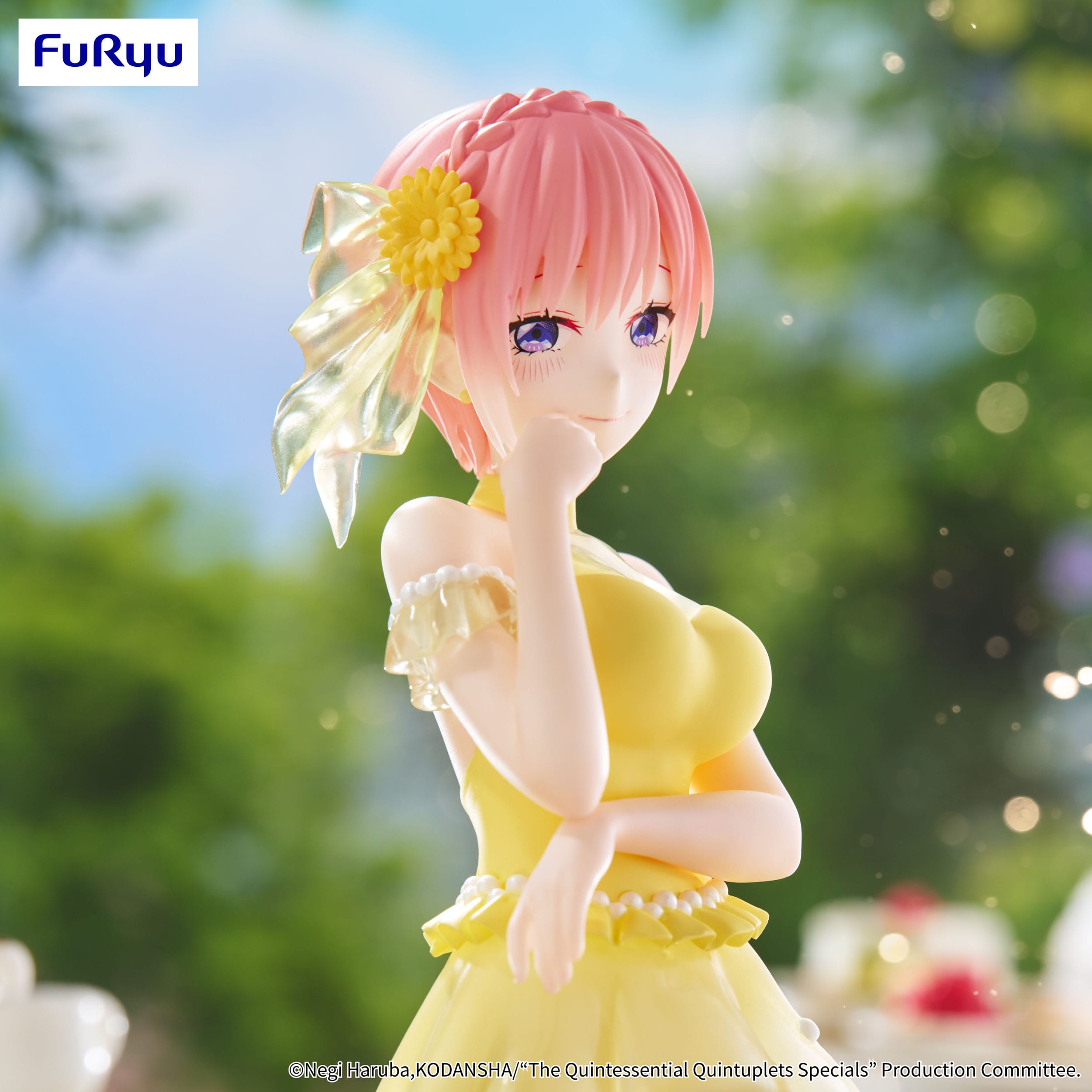 Anime figurine with pink hair and a yellow dress, blurred greenery in the background