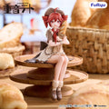 A detailed anime figurine of Kasane Teto  styled as a baker sitting on a wooden tiered table with a loaf of bread. The background is a warm, blurred bakery setting with baskets of bread.