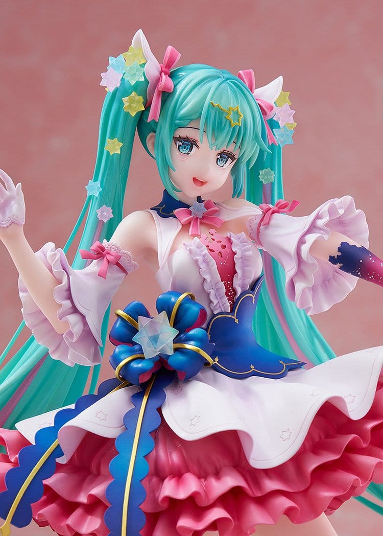 Anime character figurine with turquoise hair and colorful outfit against a pink background