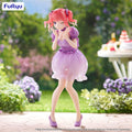 Anime figurine in a purple dress standing outdoors with flowers and a table in the background, featuring the Furyu brand.