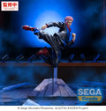 A collectible figurine of the character Yuji Itadori from Jujutsu Kaisen in a dynamic kicking pose, mounted on a wooden platform. The figure is wearing a dark gray gi with red accents.