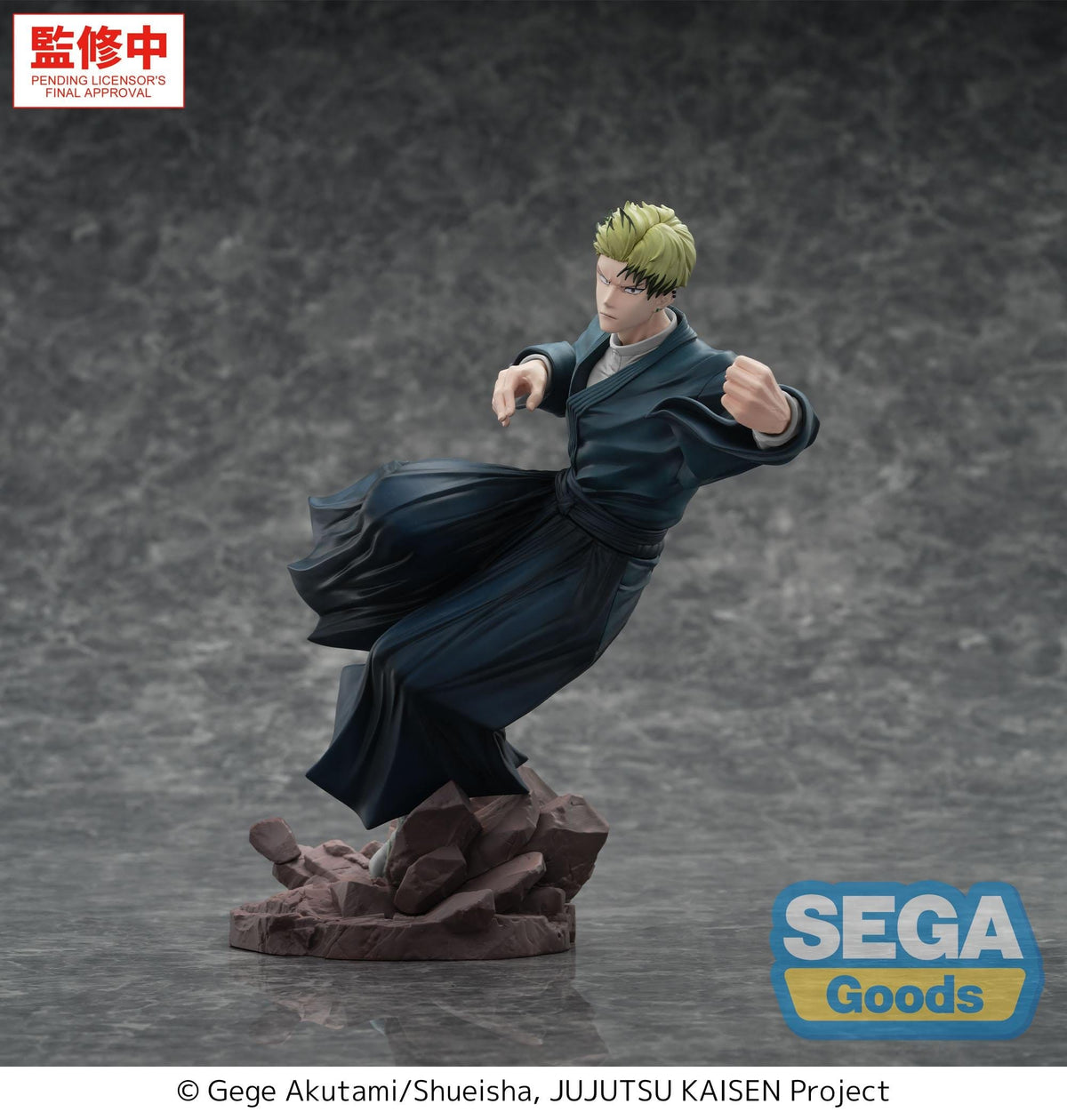 A collectible action figure of a blond anime character in a dark blue robe, posed mid-action on a rocky base against a smoky gray studio background. SEGA Goods branding and a Chinese approval badge are visible.