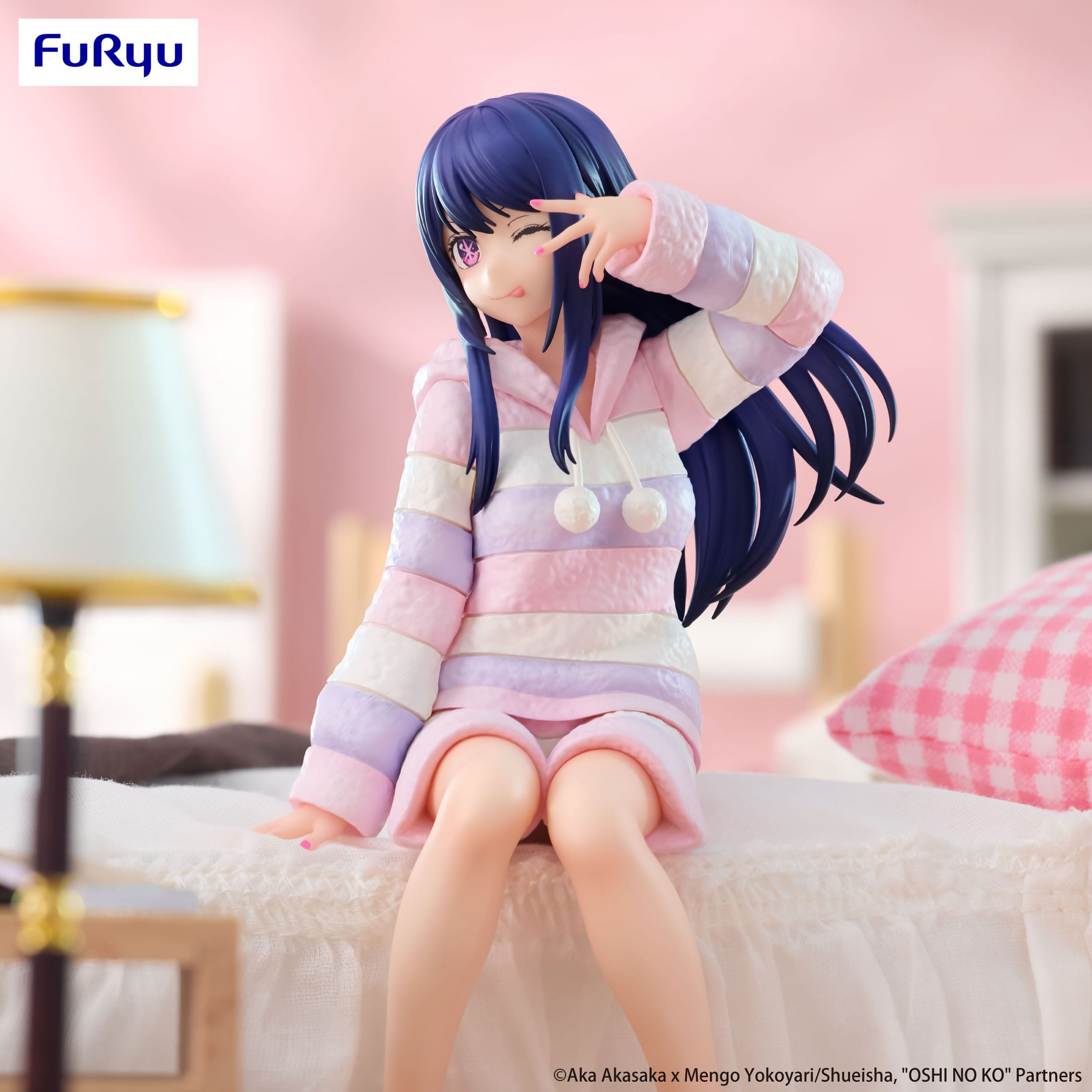 Anime character figurine in a colorful outfit sitting on a bed with a blurred background