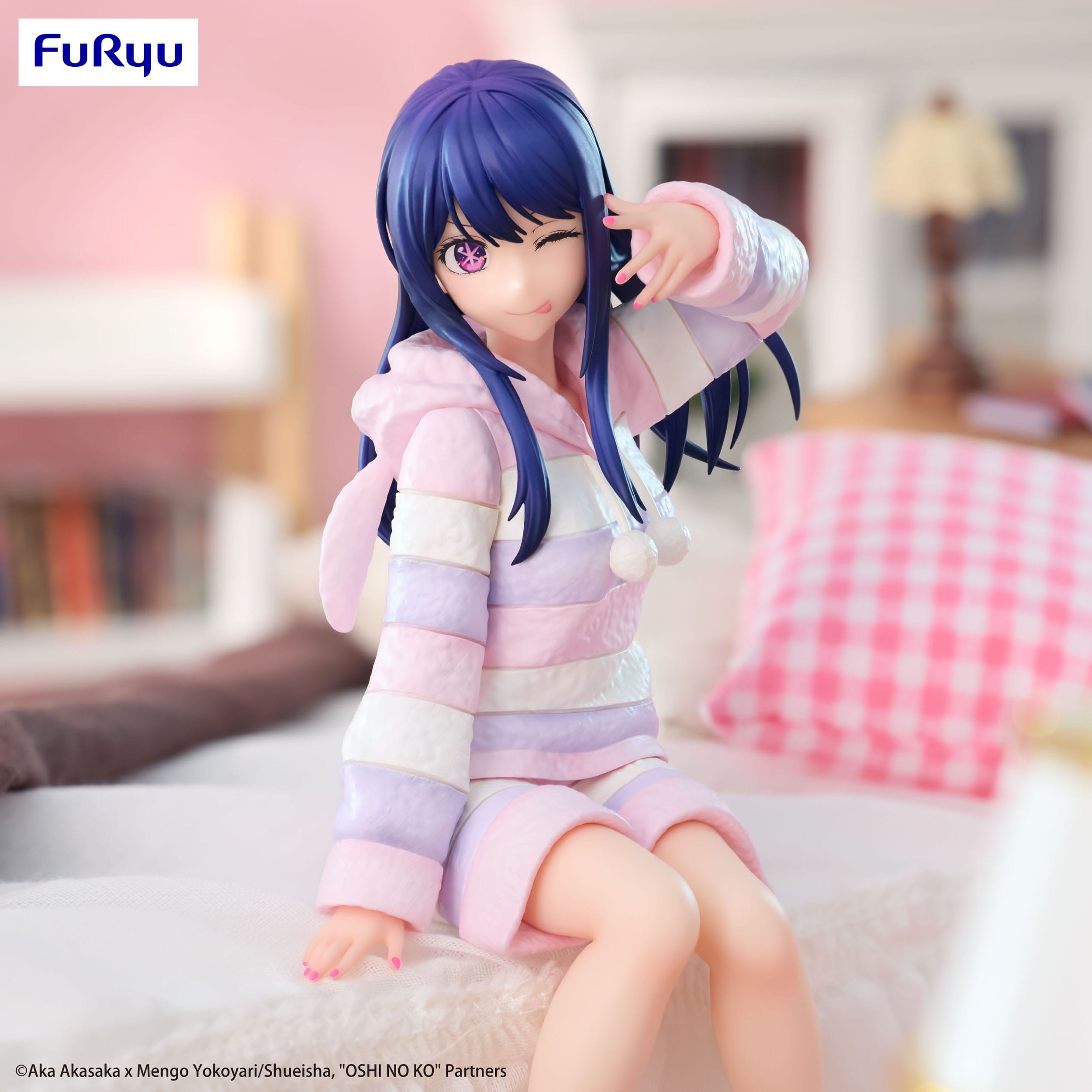 Figurine of a character in a pastel outfit with blue hair, sitting on a bed.