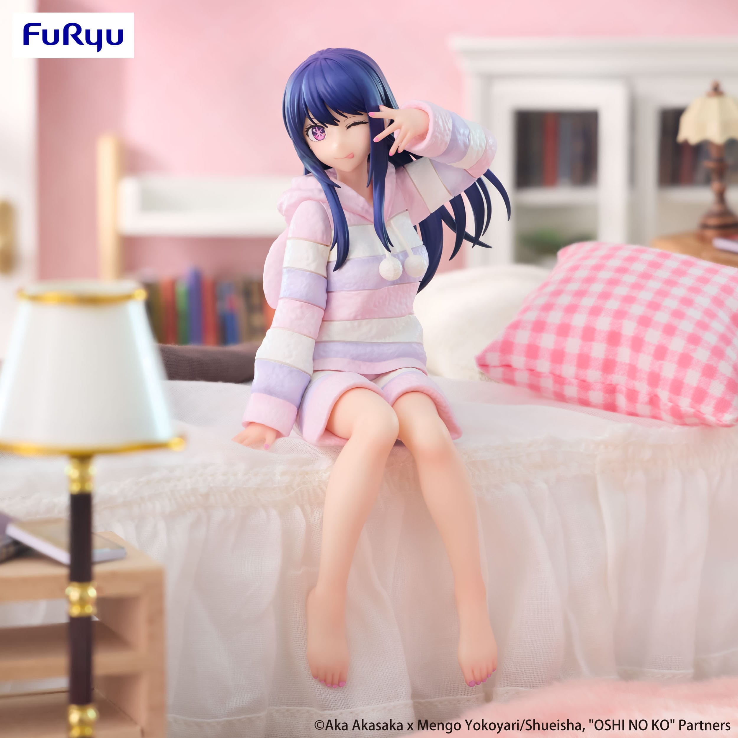 Figurine of a character with blue hair and a striped outfit sitting on a bed in a room.